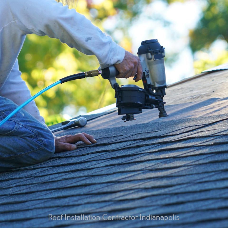 A roofer uses a pneumatic nail gun to install asphalt shingles on a residential roof.