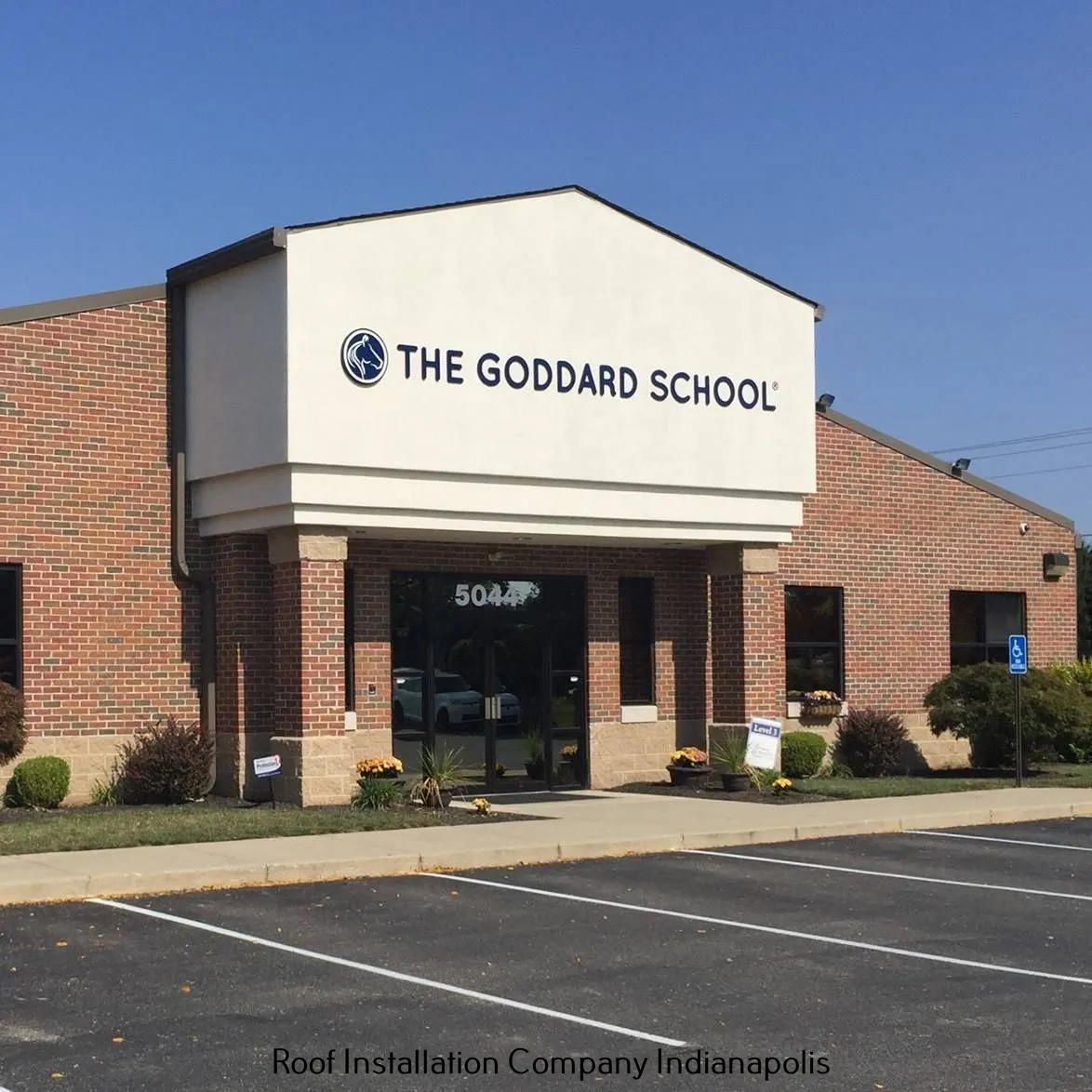 Exterior view of a brick Goddard School building in Indianapolis under a clear blue sky.
