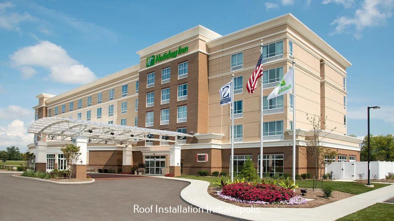 A Holiday Inn hotel exterior with a tan facade, brick accents, a covered entrance, and three flags in front.