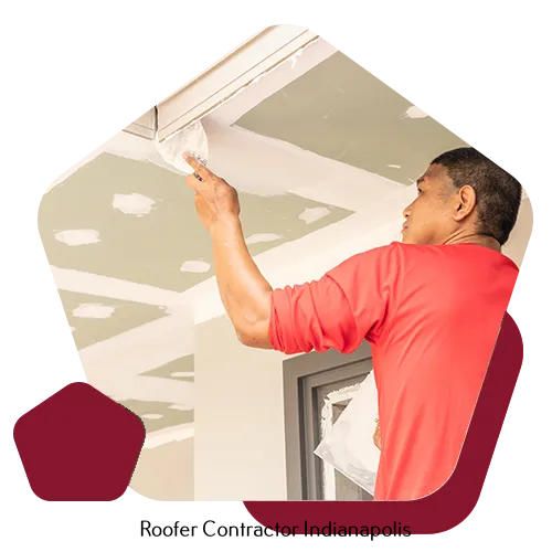 A construction worker in a red shirt applying joint compound to a ceiling in a room under renovation.