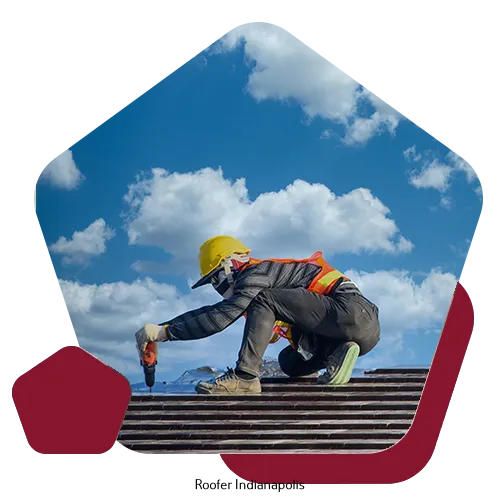 A roofer wearing a yellow hard hat and high-visibility vest uses a drill on a shingled roof against a cloudy blue sky.