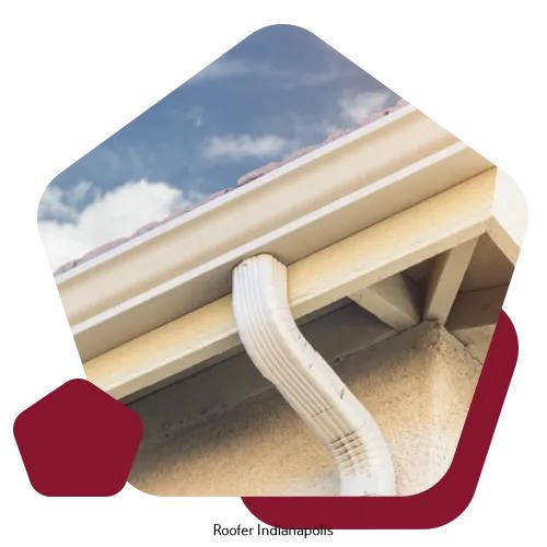 A white metal gutter and downspout attached to a light-colored stucco house exterior under a cloudy sky.
