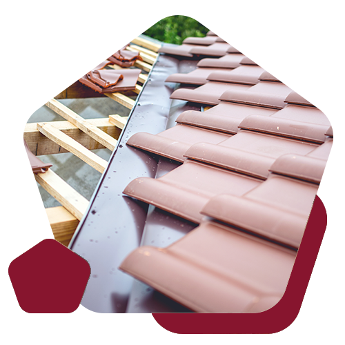 A roof under construction featuring wooden battens on one side and finished reddish-brown roof tiles on the other.