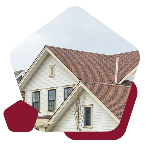A multi-gabled house exterior with white horizontal siding and a brown shingled roof, framed by burgundy shapes.