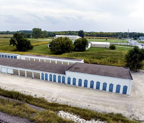 An aerial view of a row of storage units in a field.