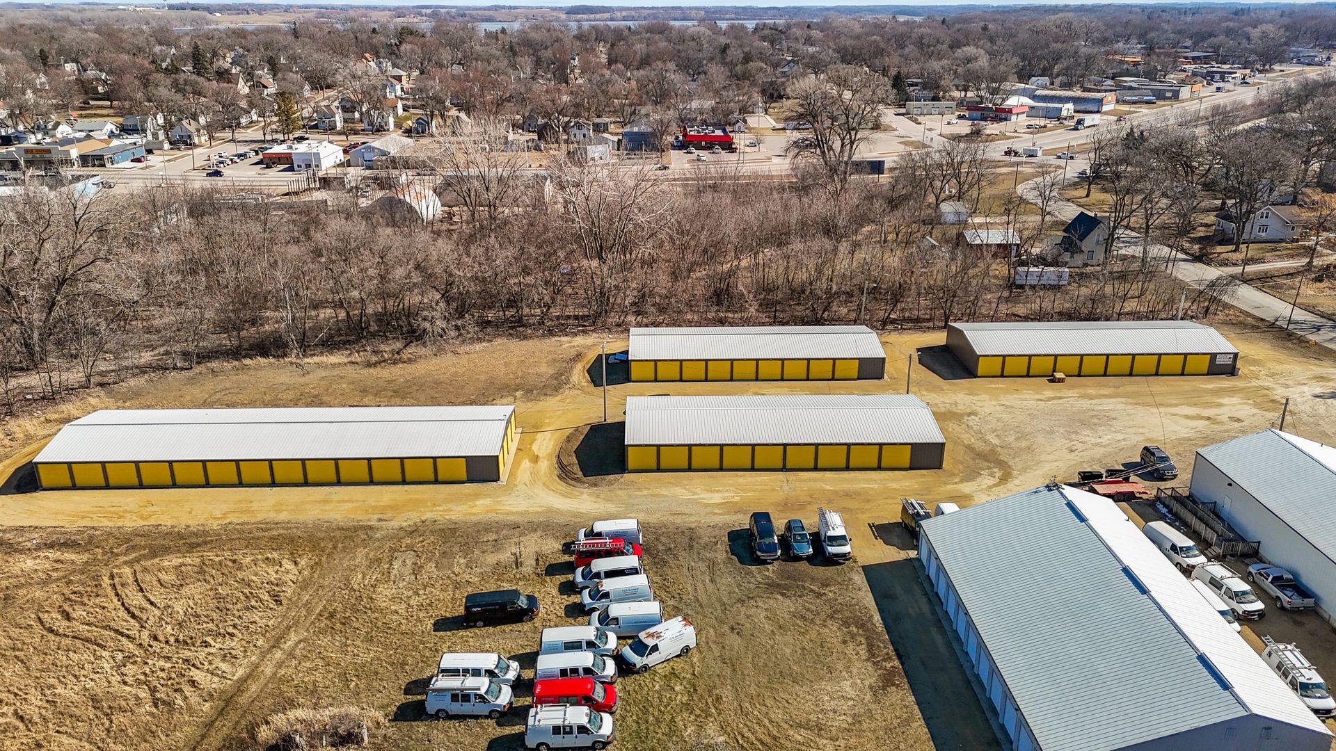 An aerial view of a storage facility with a lot of cars parked in front of it.