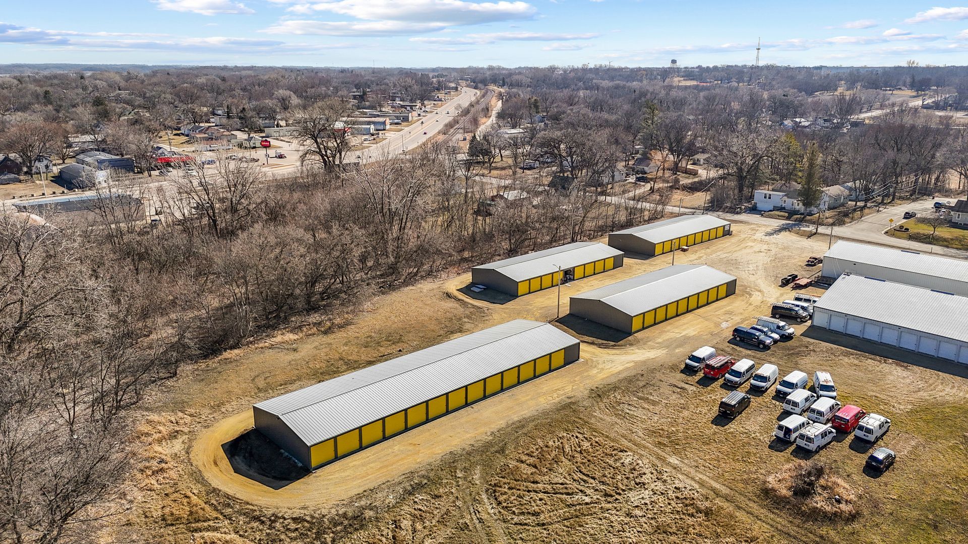 An aerial view of a storage facility with a lot of cars parked in front of it.