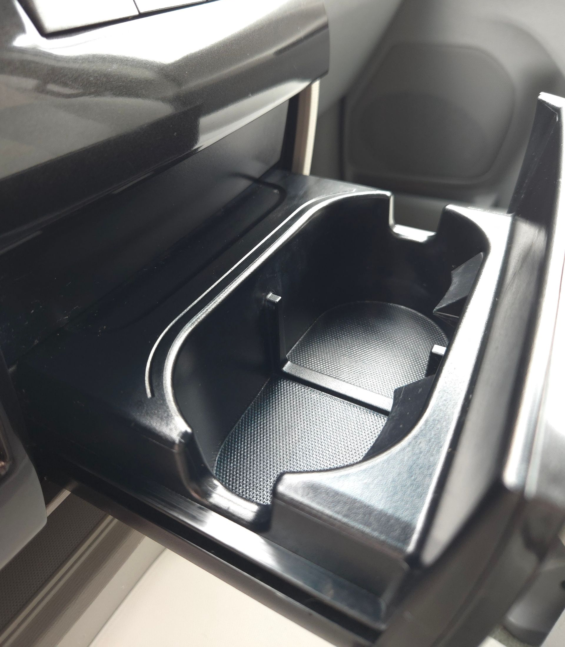Black car cup holder in a console.