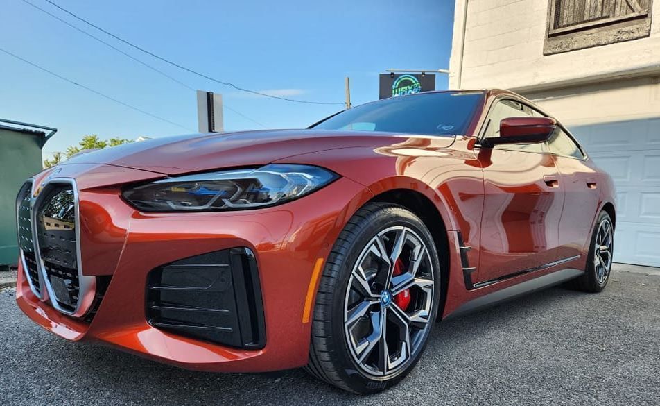 Red BMW sports car parked in front of a building with a blue sky in the background.