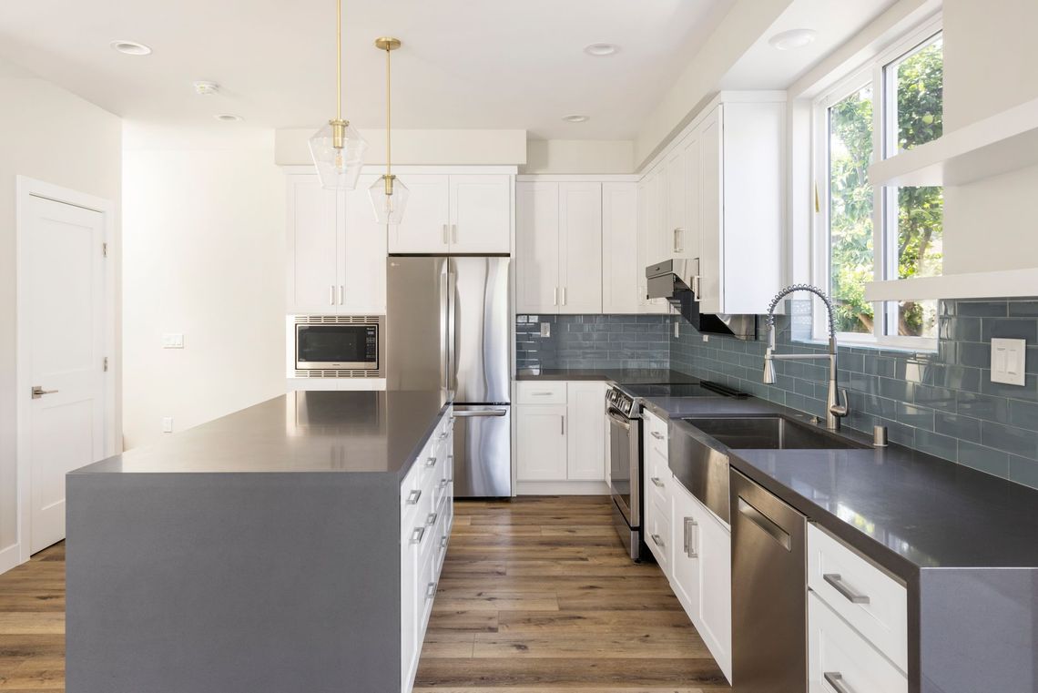 The full kitchen inside a 1200 square foot, three-bedroom, two story accessory dwelling unit (ADU) in Los Angeles, CA featuring plenty of space, an island, and modern all-electric appliances. 