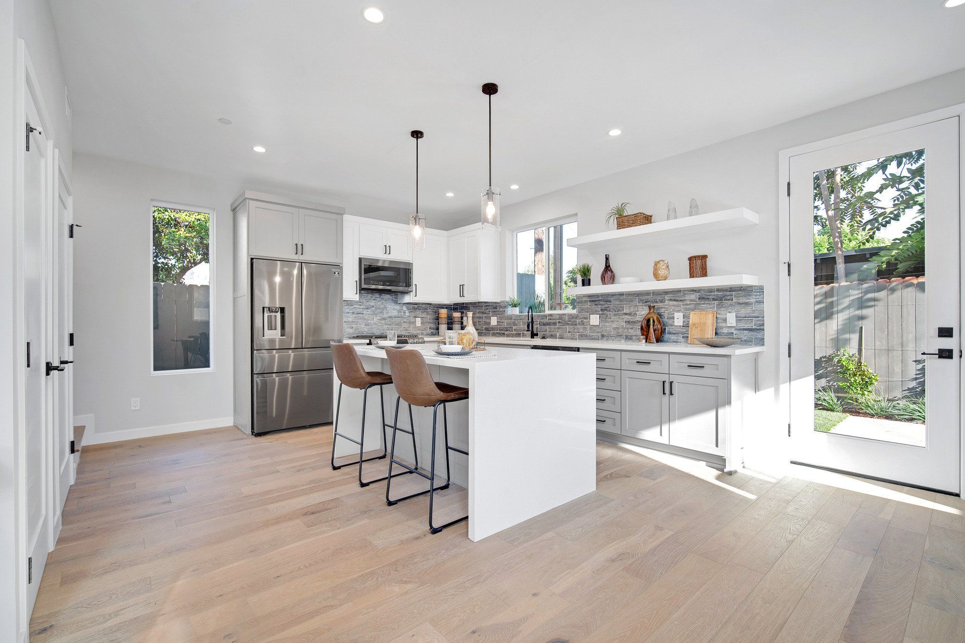 The full kitchen inside an accessory dwelling unit (ADU) backyard home, featuring plenty of space, an island, and modern all-electric appliances. 