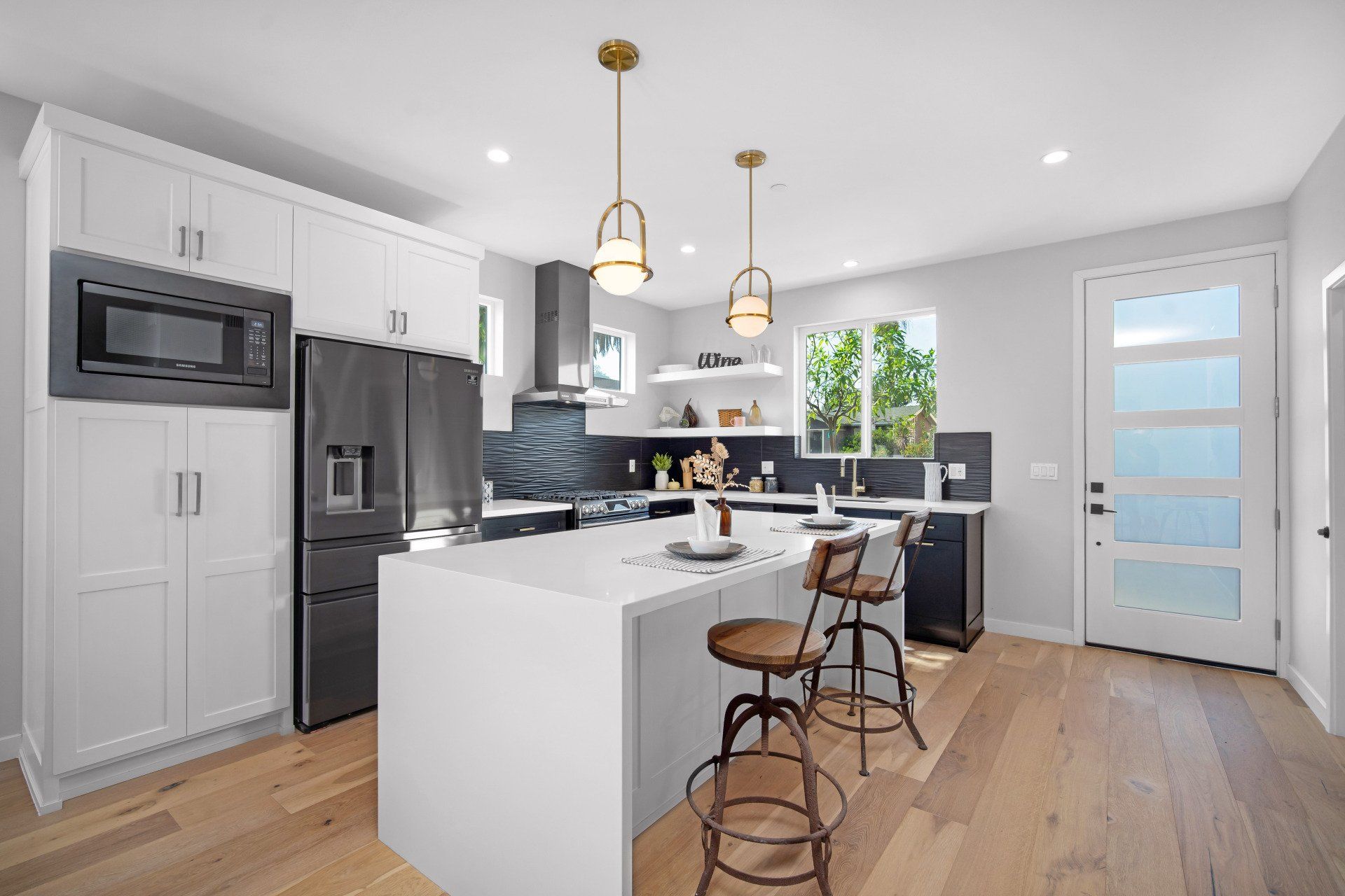 The full kitchen inside an accessory dwelling unit (ADU) backyard home, featuring plenty of space, an island, and modern all-electric appliances. 