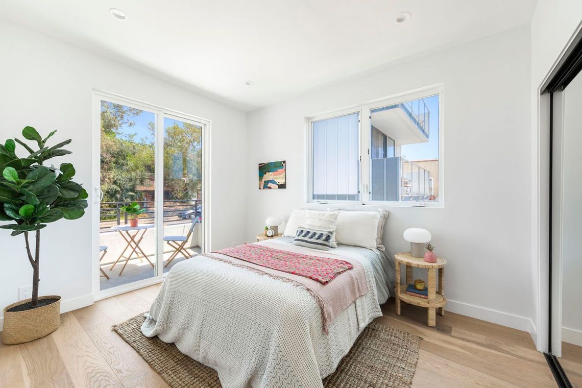 The spacious master bedroom in an accessory dwelling unit (ADU) casita with sliding glass doors leading to a sunny outdoor patio.