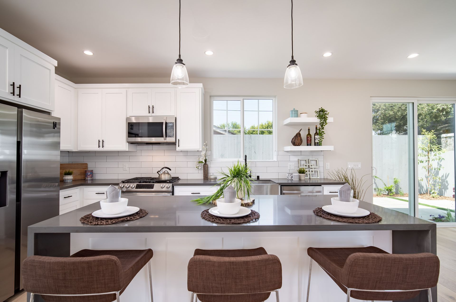 The full kitchen inside an accessory dwelling unit (ADU) backyard home, featuring plenty of space, an island, and modern all-electric appliances. 