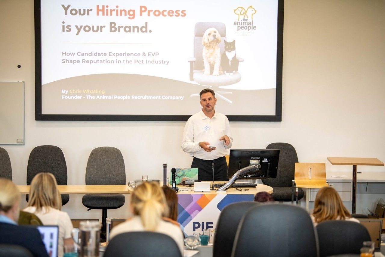 Presenter speaking in classroom, with slide reading “Your Hiring Process is your Brand.”