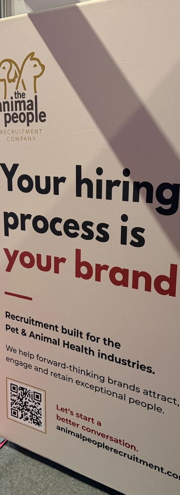 Poster with bold black and red text reading “Your hiring process is your brand” on a beige background