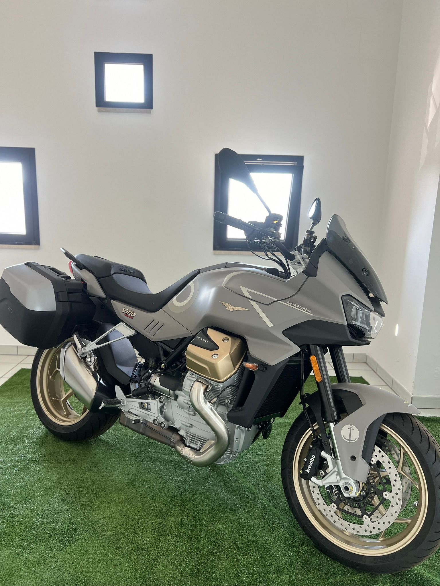 Una moto è parcheggiata in cima a un tappeto verde in una stanza.