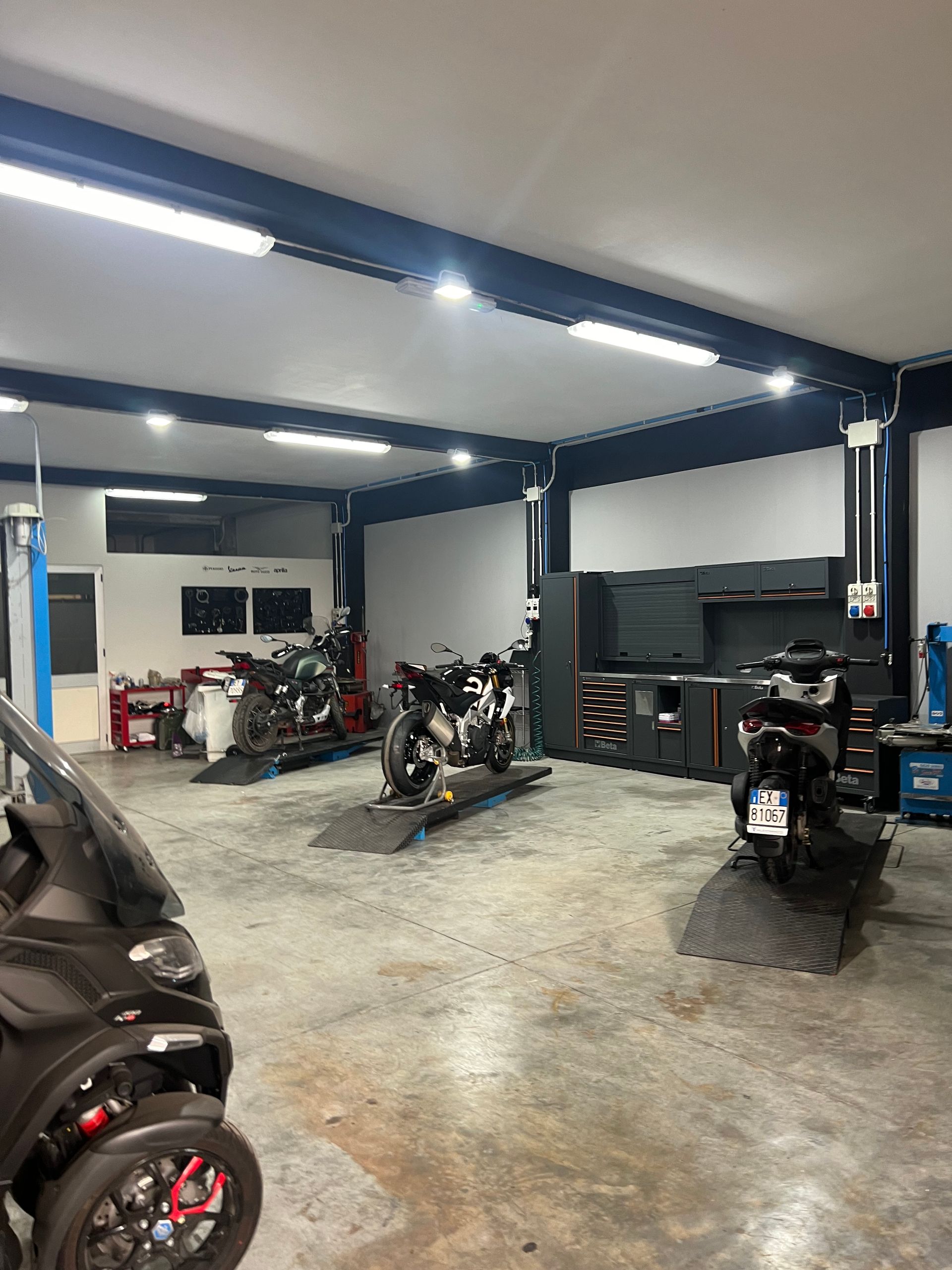 Un garage pieno di motociclette e una smart.
