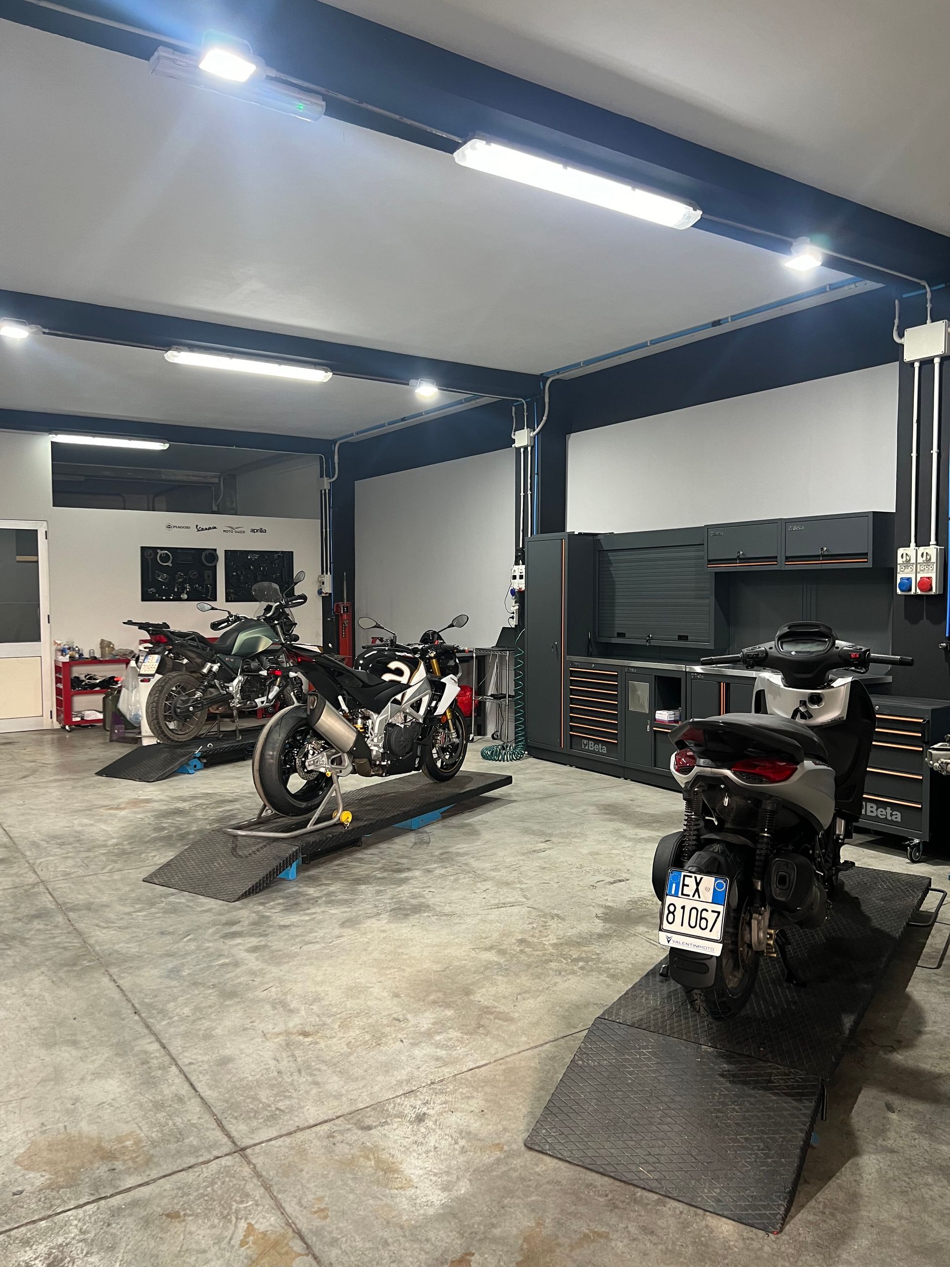 Una fila di motociclette sono parcheggiate in un garage.