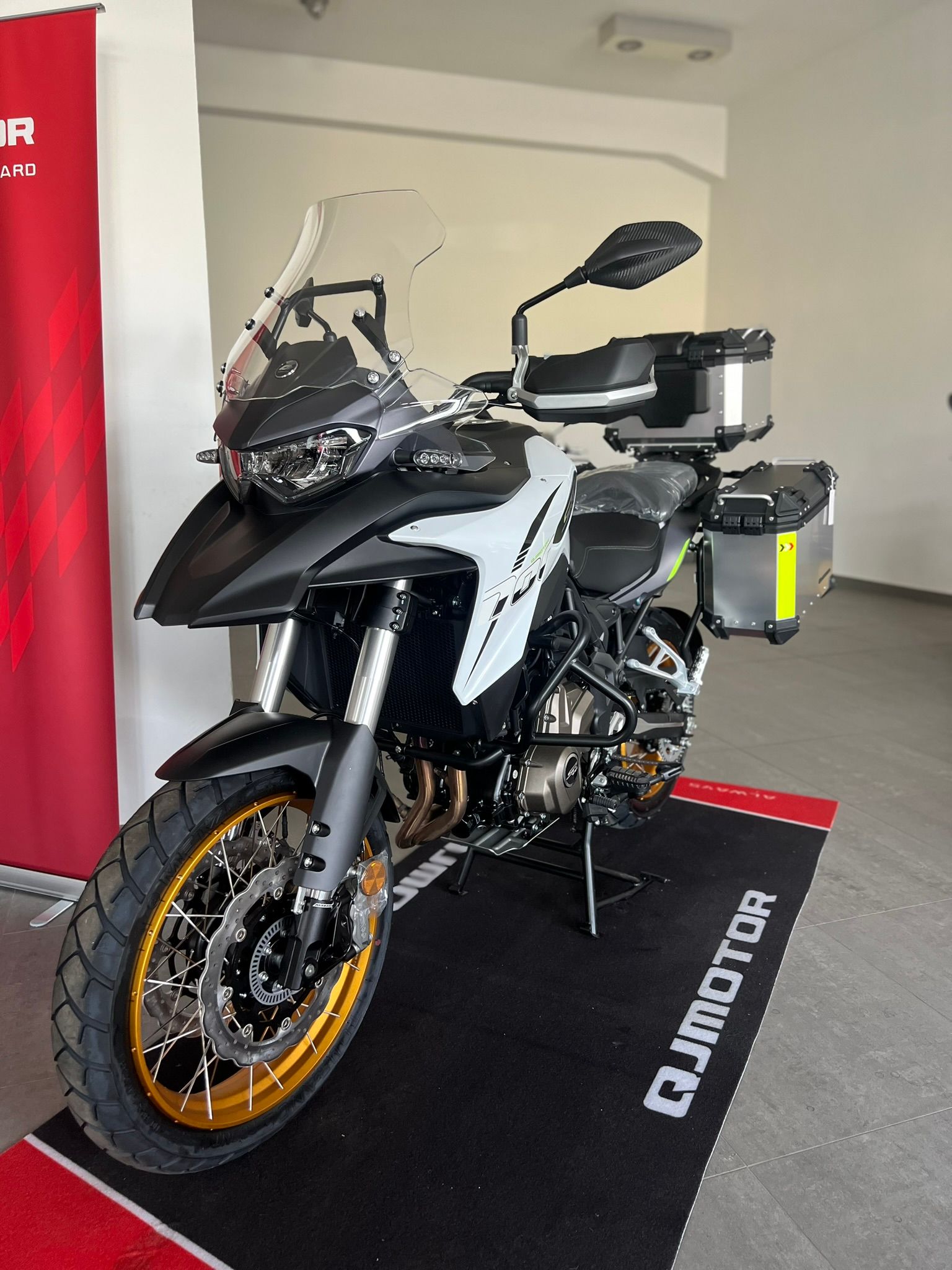 Una moto è parcheggiata su uno zerbino in una stanza.