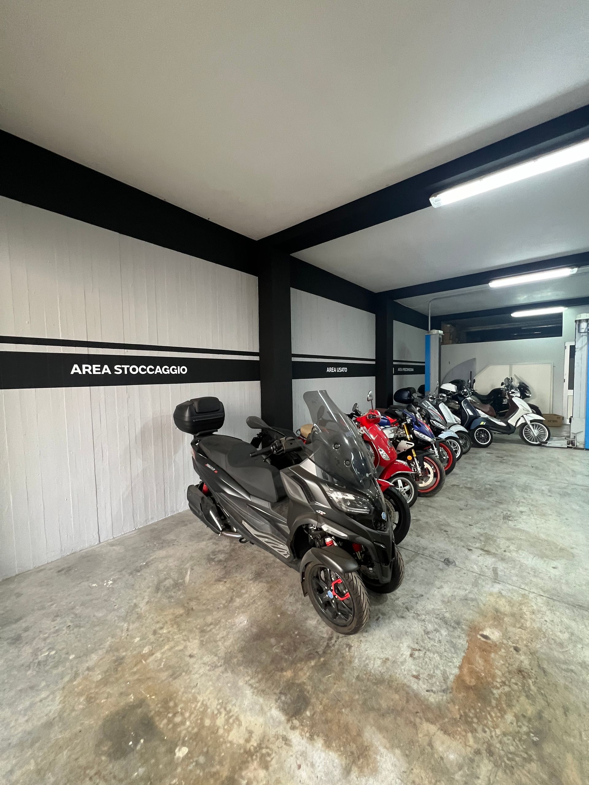 Una fila di motociclette sono parcheggiate in un garage.