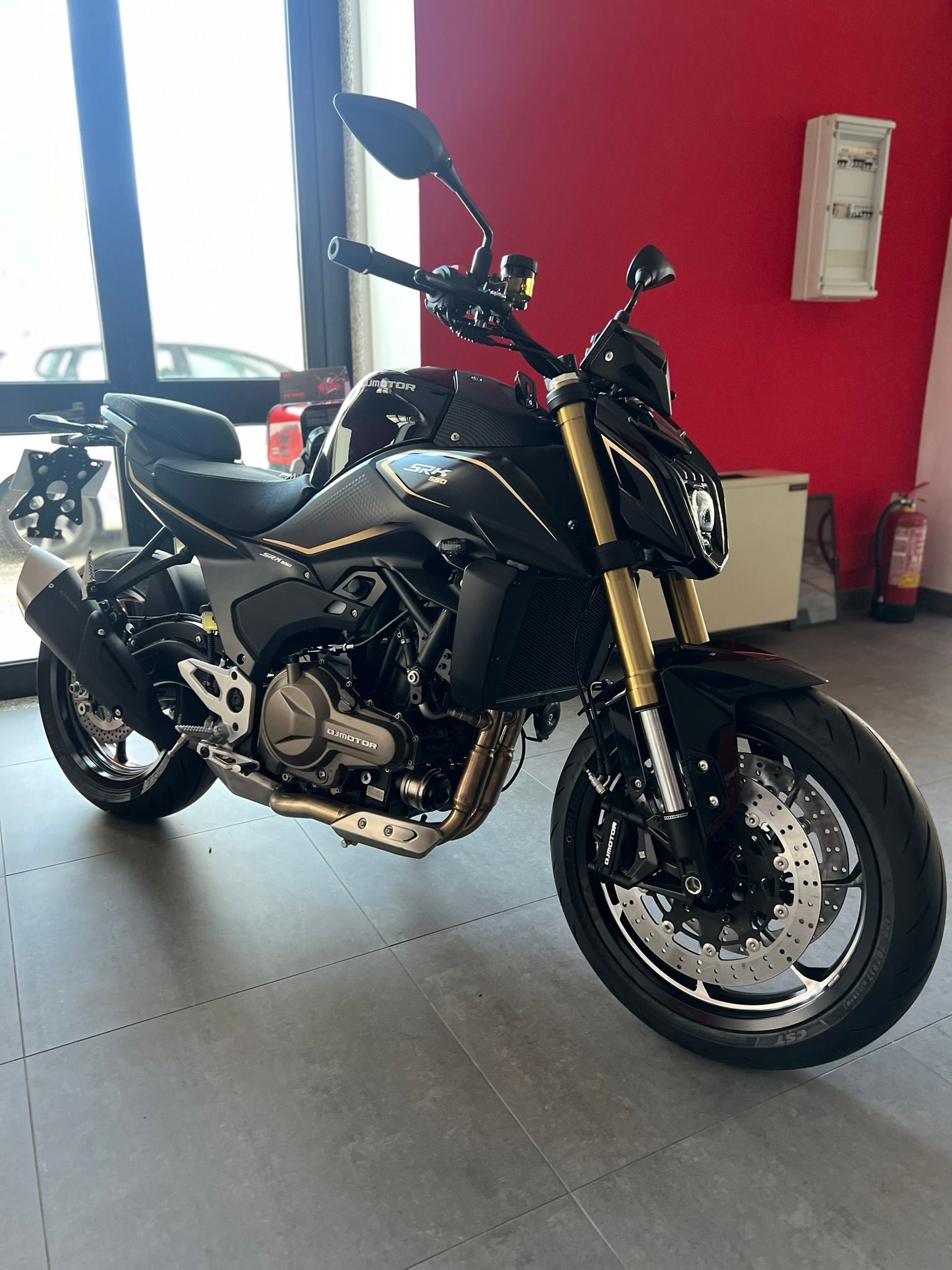 Una moto nera è parcheggiata in uno showroom.