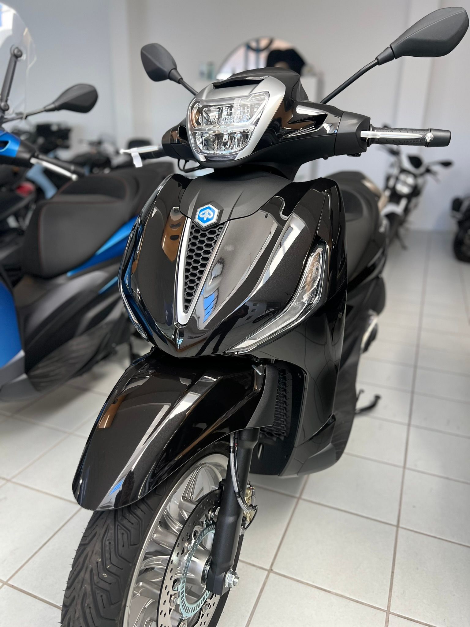 Uno scooter nero è parcheggiato in uno showroom.