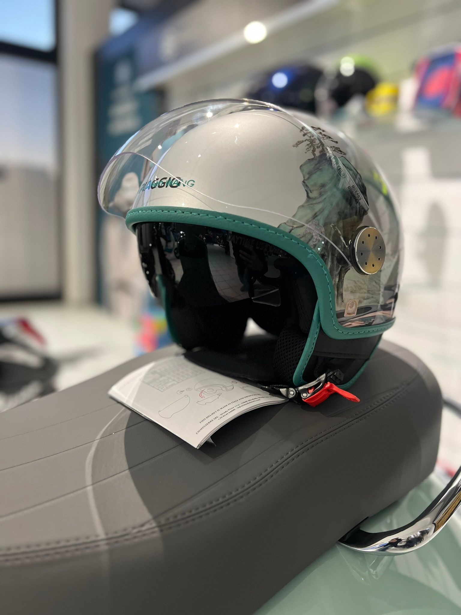 Un casco è appoggiato sul sedile di uno scooter.