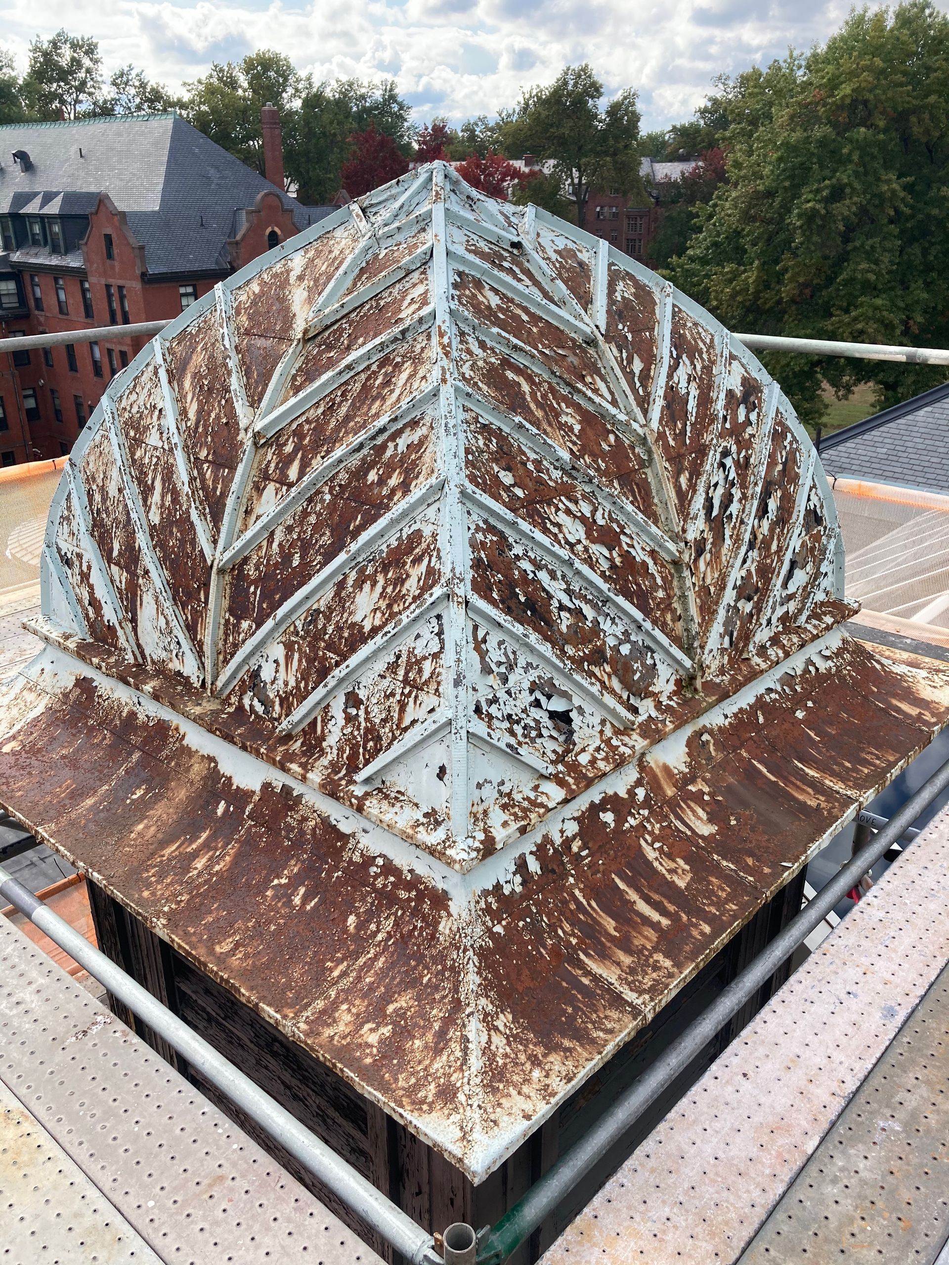 A rusty dome is sitting on top of a scaffolding.