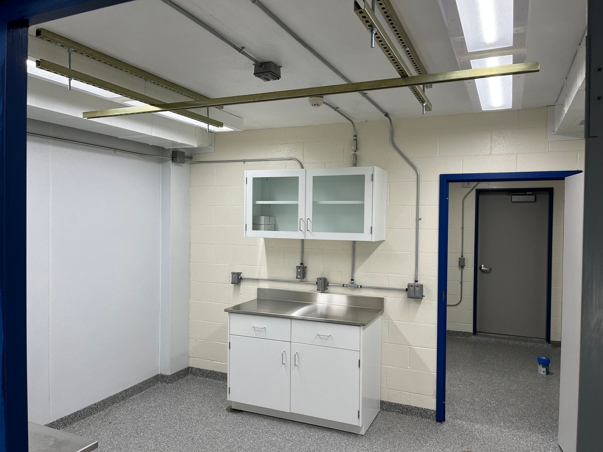 A kitchen with white cabinets and a stainless steel counter top