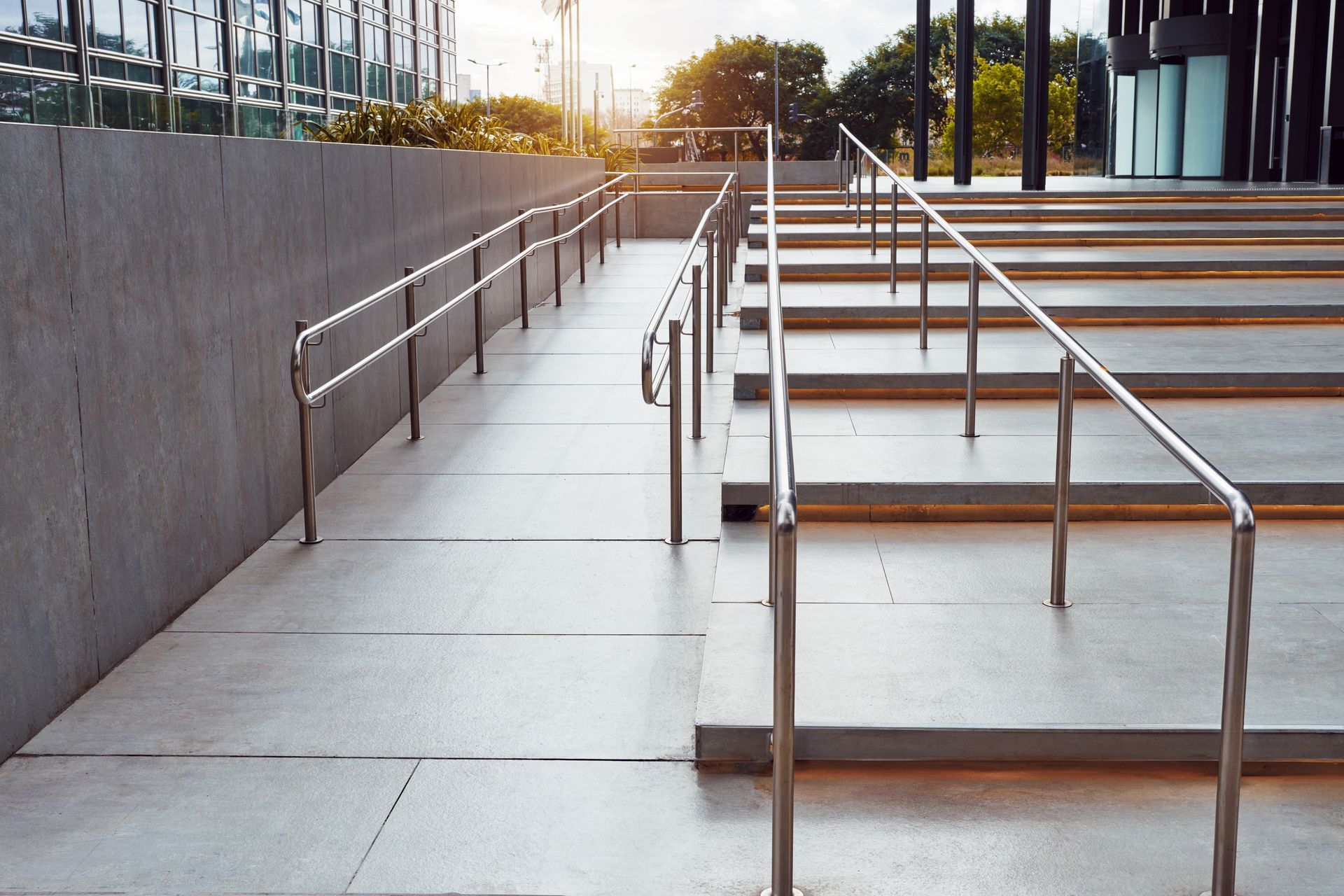 A ramp leading up to a set of stairs with a metal railing