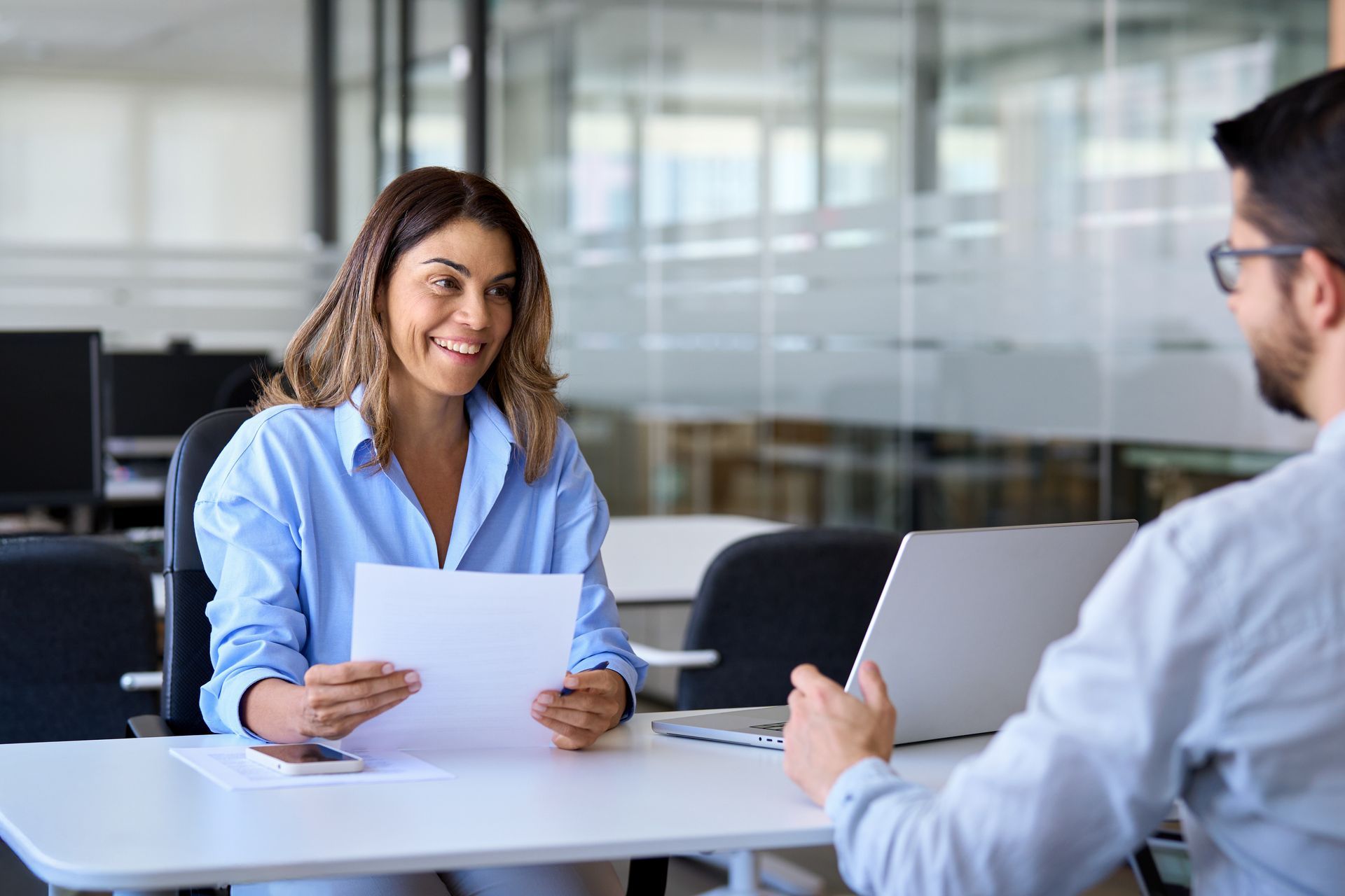 A smiling professional female or employer having a job interview meeting with a male candidate. A smiling professional female or employer having a job interview meeting with a male candidate.