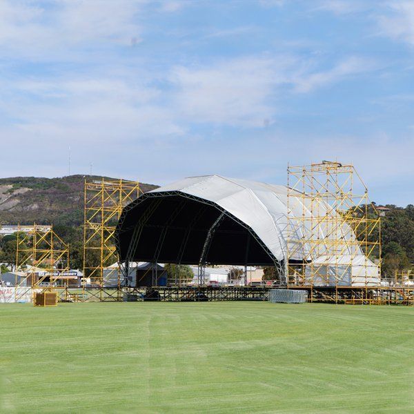 A large tent is sitting in the middle of a grassy field.