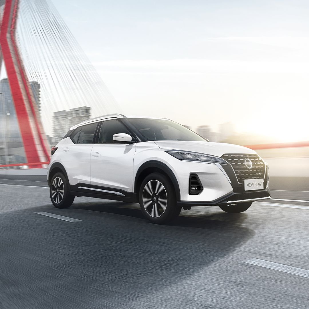 Uma caminhonete Nissan azul está dirigindo por uma estrada.