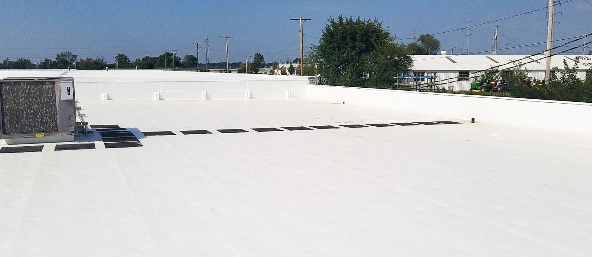 Crew applying PolyArmor coating on a flat roof