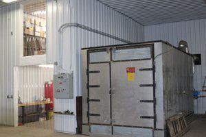 A large stainless steel container is sitting inside of a building.