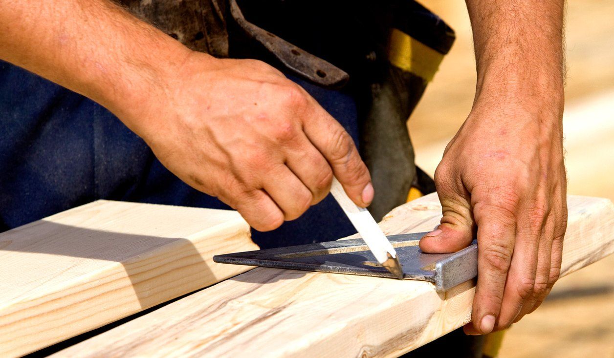 Handyman measuring and repairing wooden deck boards during a residential deck repair