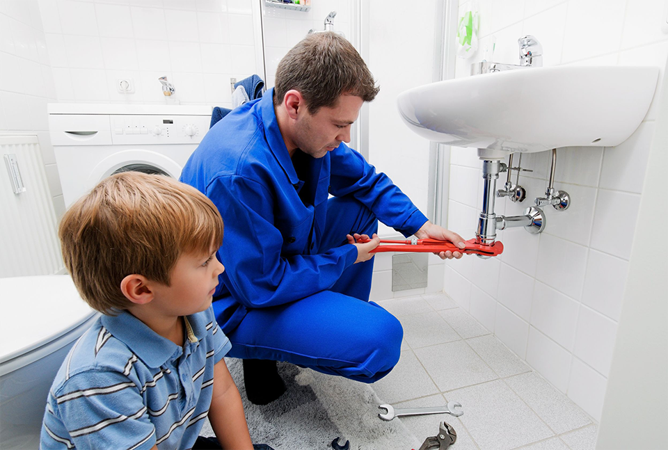 A1 Handyman repairing a water leak under a bathroom sink