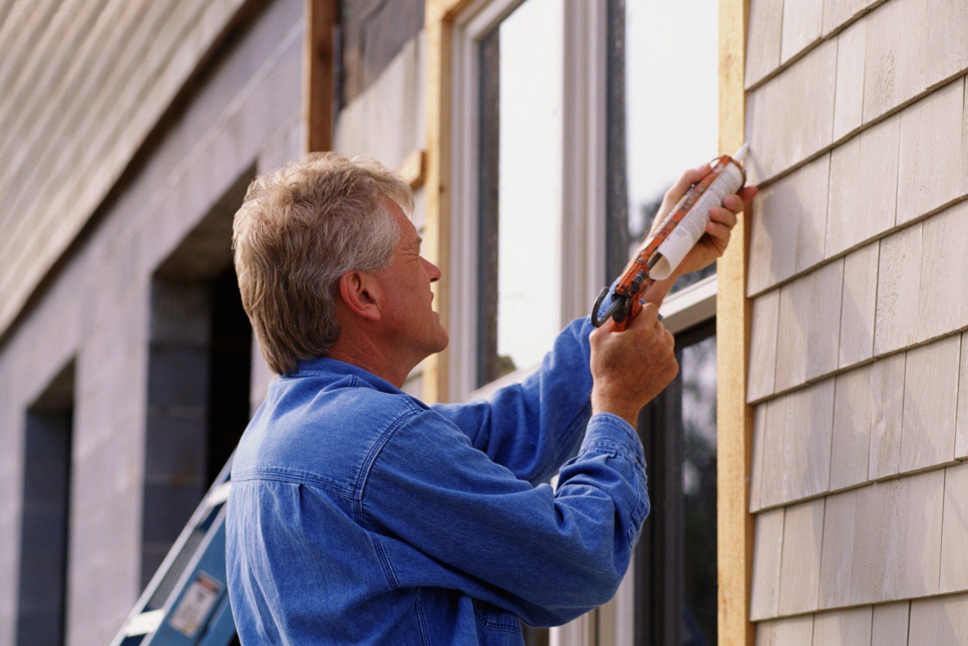 Re-caulking windows and siding on a Boise, ID home to seal gaps after winter weather