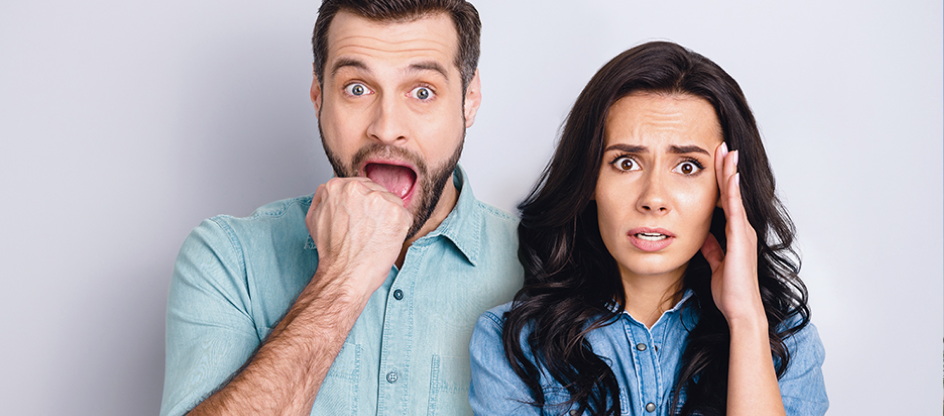 A man and a woman are standing next to each other with their mouths open.