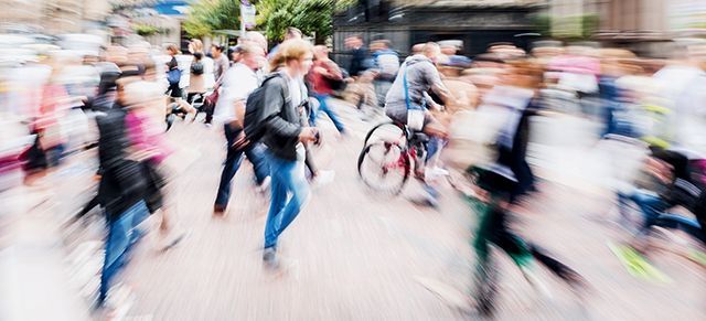 A blurry picture of a crowd of people walking down a street.