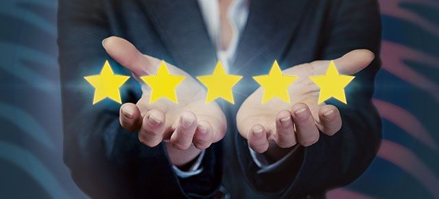 A woman in a suit is holding four stars in her hands.
