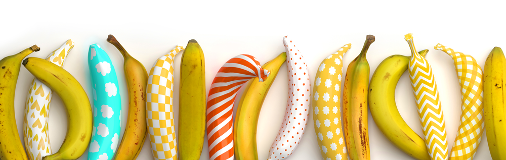 A bunch of bananas are lined up in a row on a white surface.