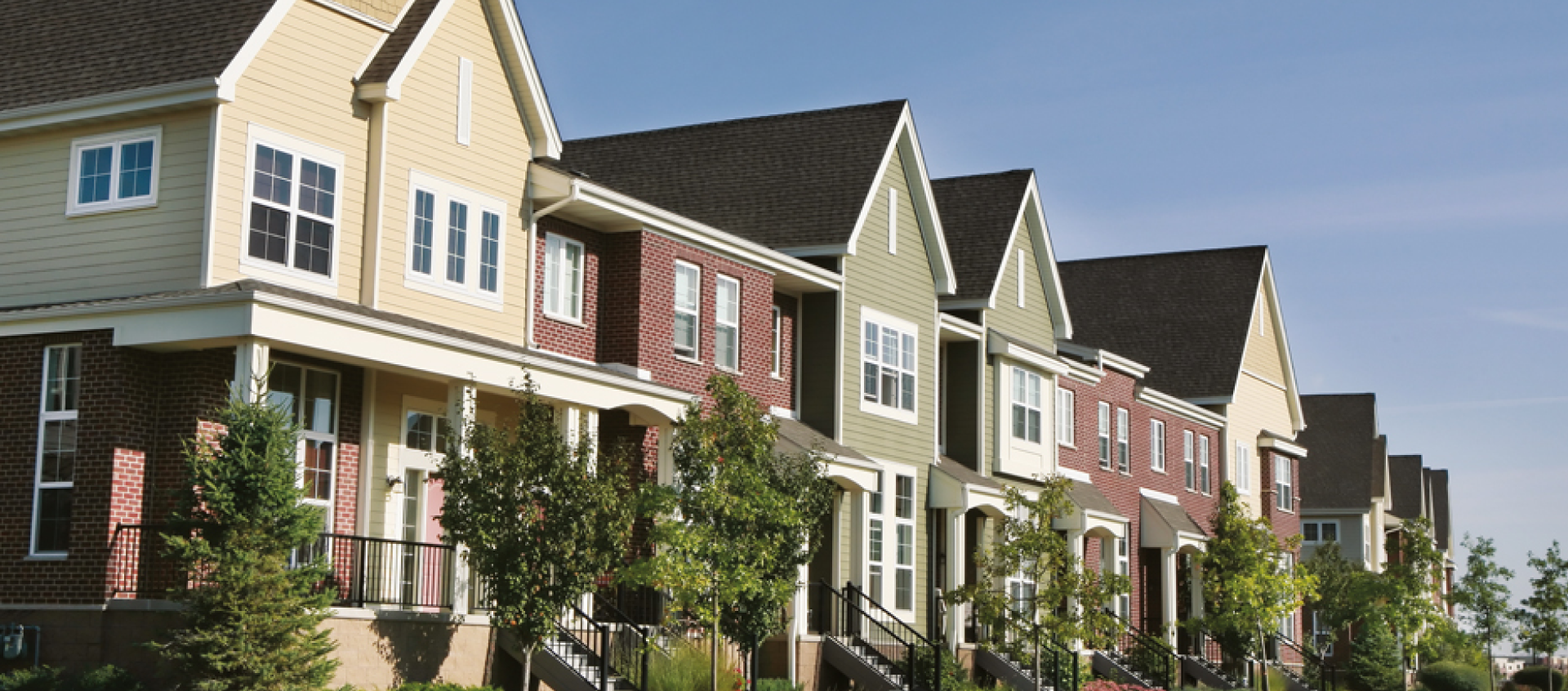 A row of houses with a blue sky in the background