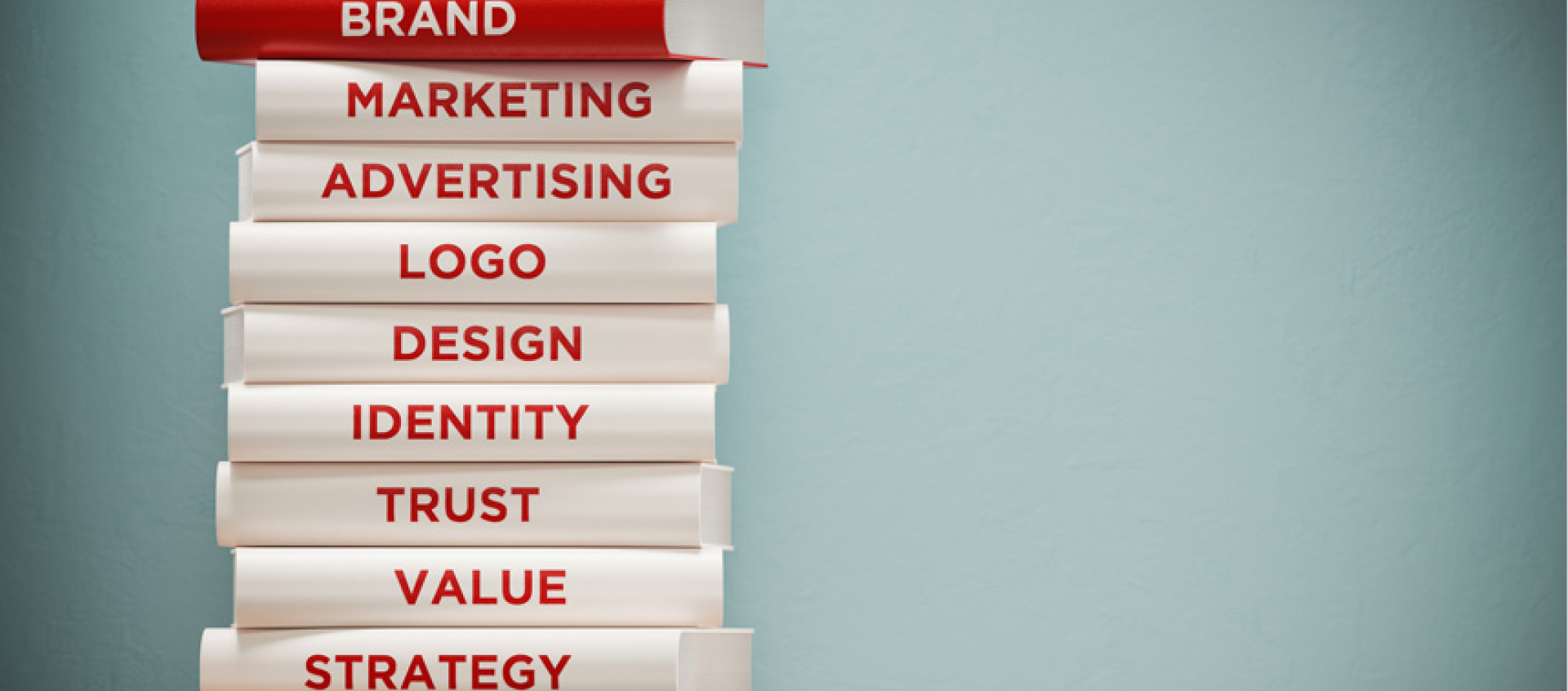 A stack of books titled brand marketing advertising logo design identity trust value strategy