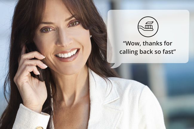 A woman is smiling while talking on a cell phone