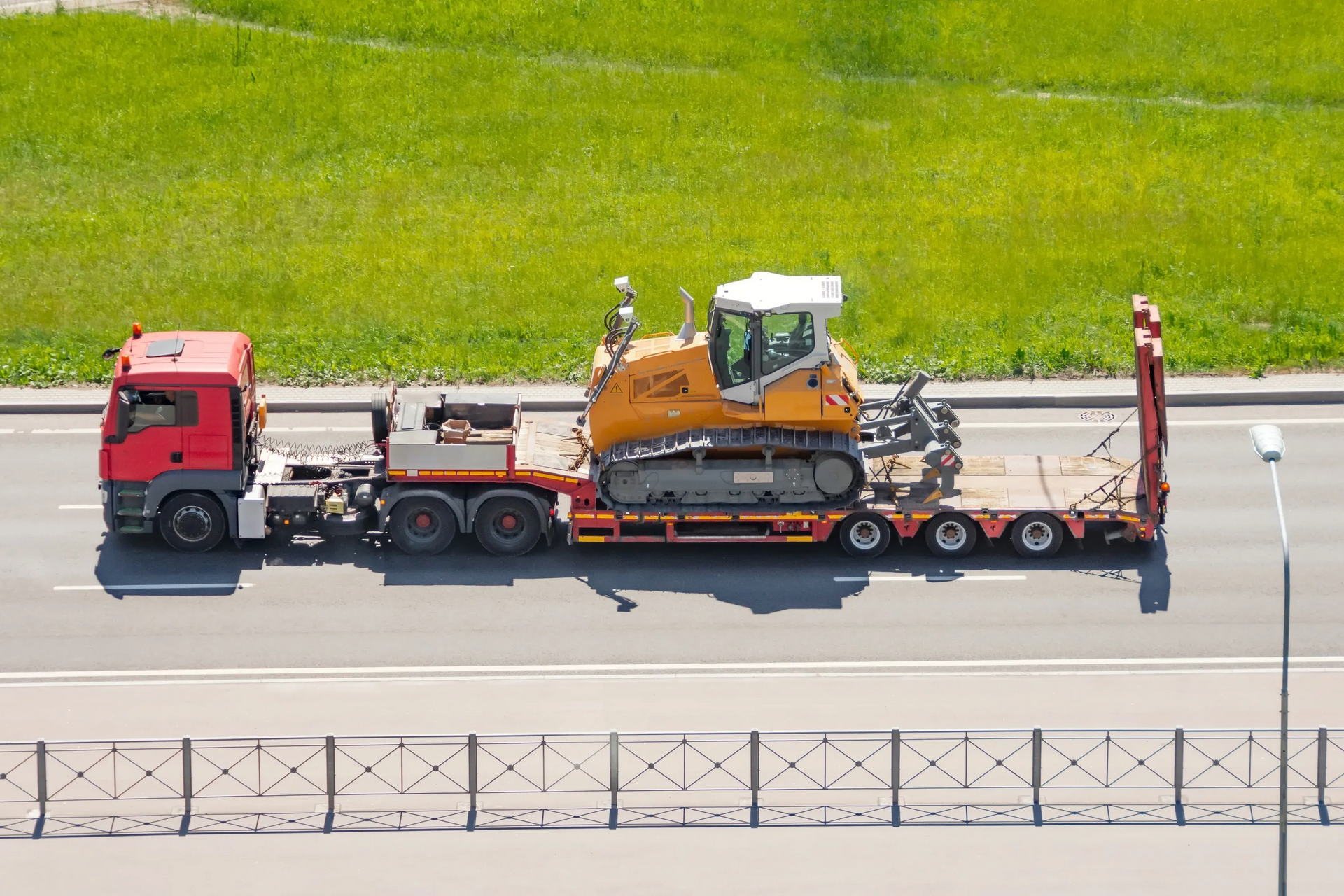 Blue Truck Carrying Heavy Equipment on a Red Trailer Driving on a Highway — All Sunshine Coast Towing In Forest Glen, QLD