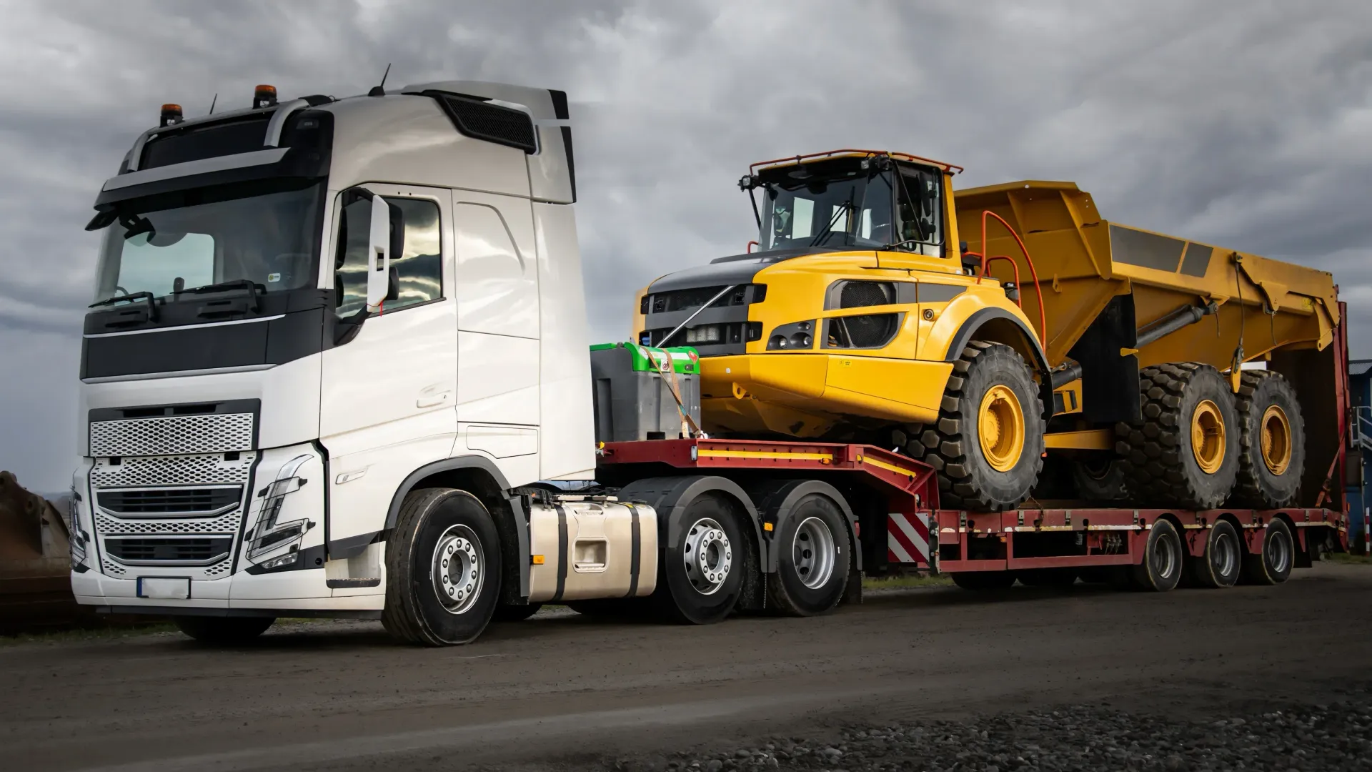 White semi-truck hauling a yellow dump truck on a red lowboy trailer — All Sunshine Coast Towing In Forest Glen, QLD