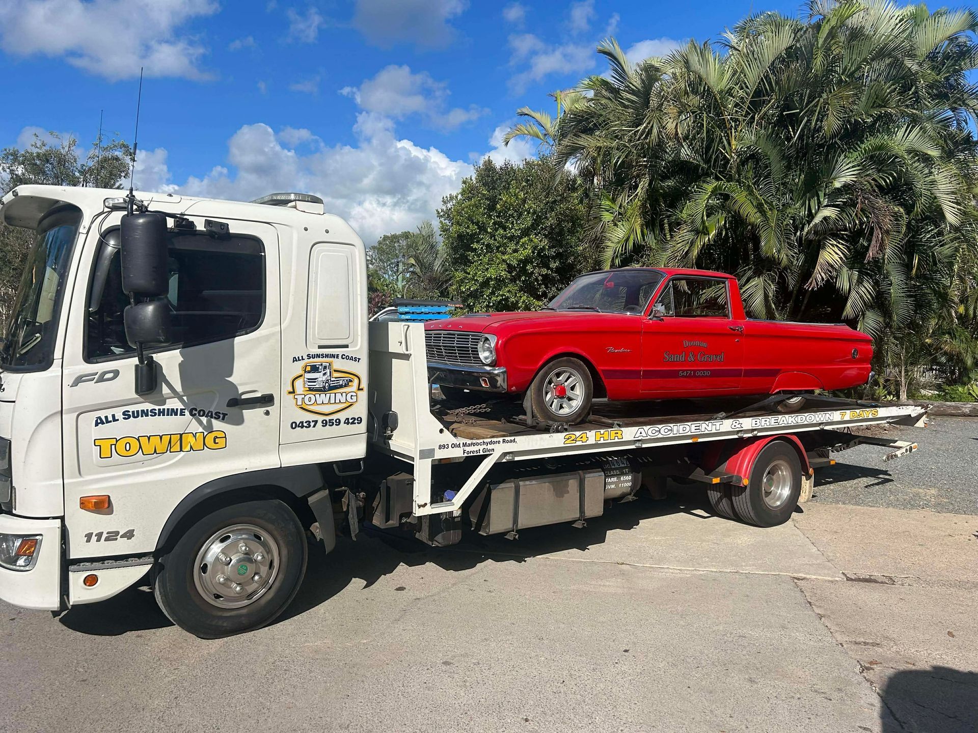Red car loaded on a white tow truck in a sunny outdoor lot.— All Sunshine Coast Towing In Maroochydore, QLD