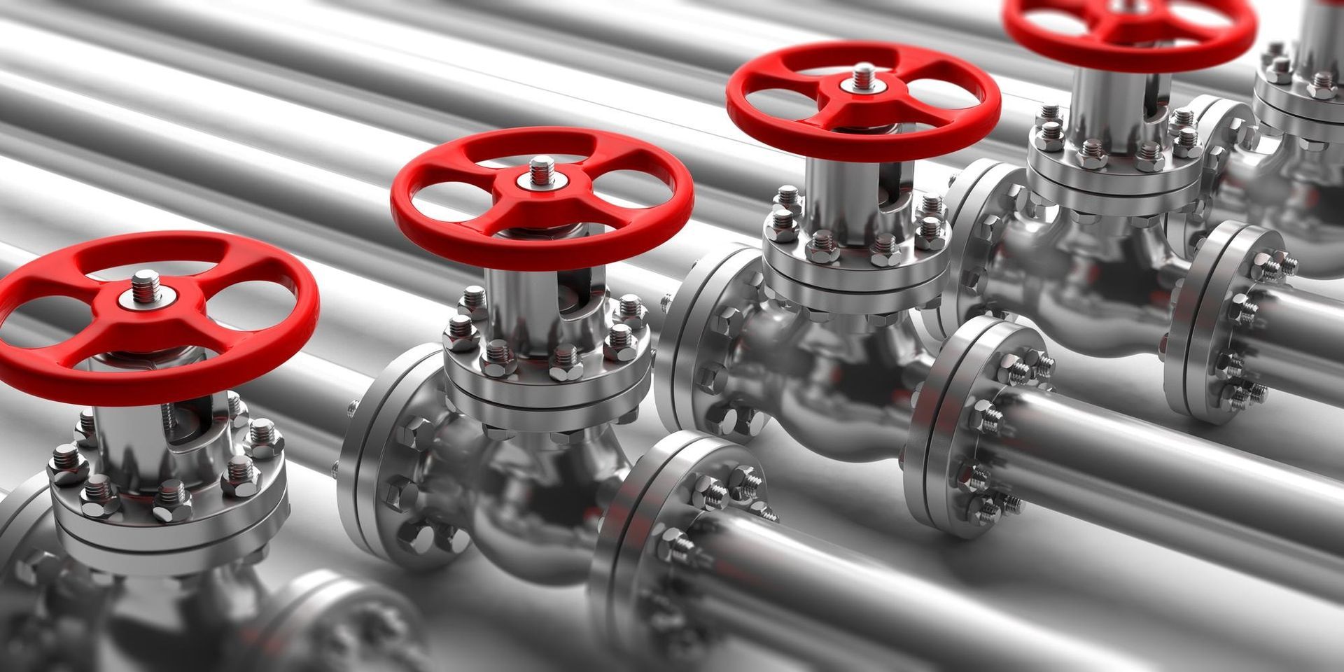 Eine Reihe glänzender, metallischer Industrierohre, die jeweils mit einem leuchtend roten, runden Handventilgriff versehen sind.
